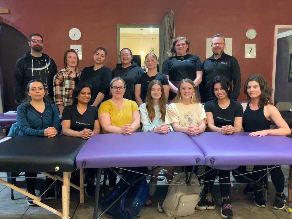 Large group of massage therapy students gathered in a clinic setting