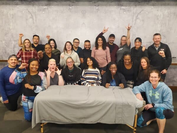 Large diverse student group in a classroom setting during a sports massage course